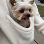Cream pet carrier hoodie worn outdoors, small dog riding in the front pouch